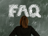 A woman looking at a board with "F.A.Q." written in large white letters.