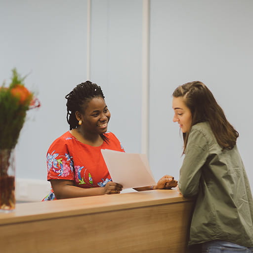 Two woman talking at a helpdesk