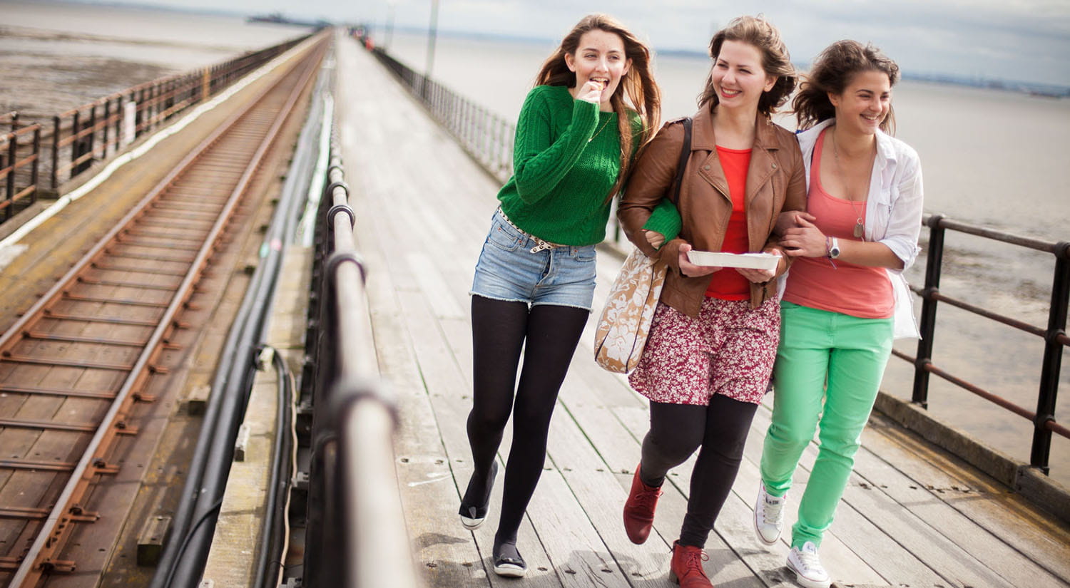 Three female students walking along the pier at Southend