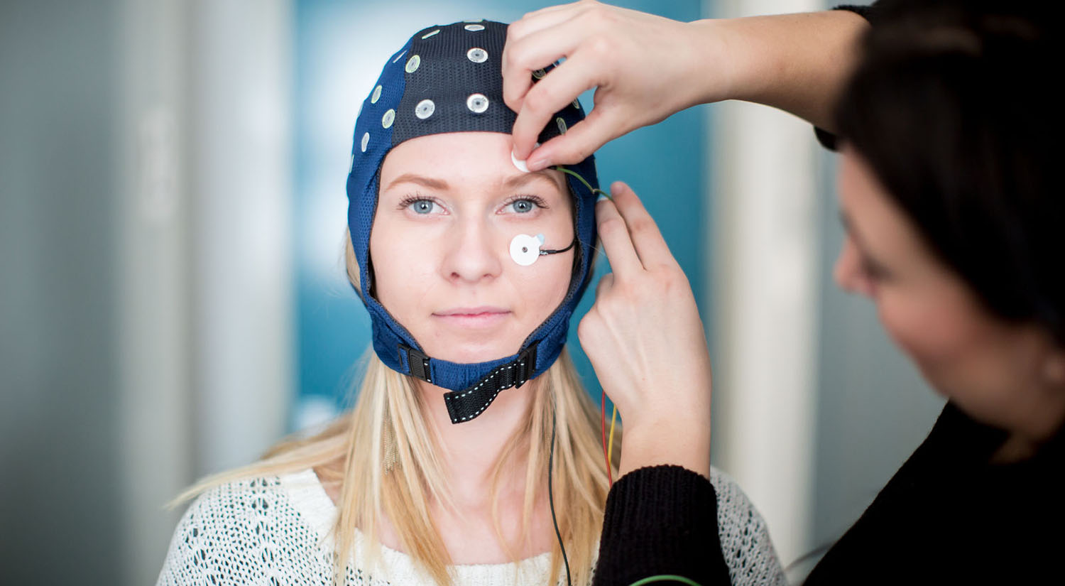 Woman being fitted with head sensor laboratory equipment