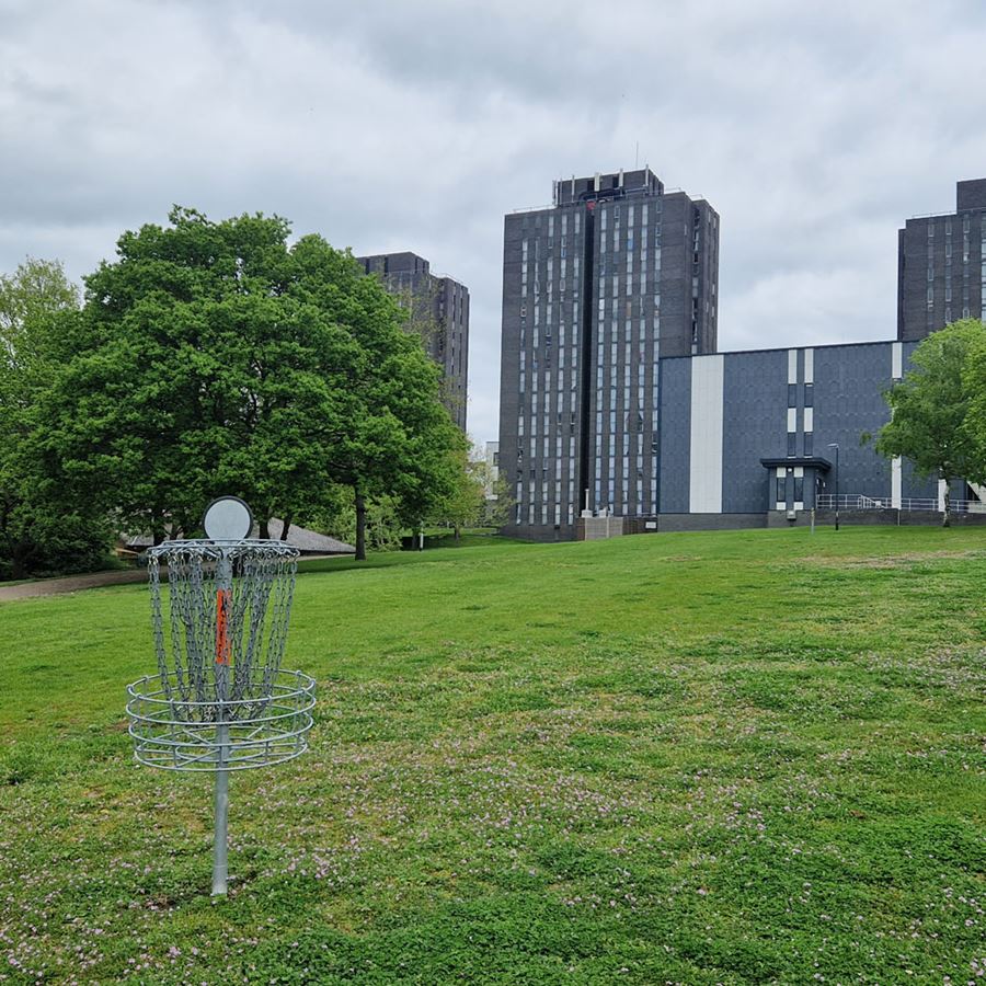 Disc Golf basket with the University Towers as it's backdrop