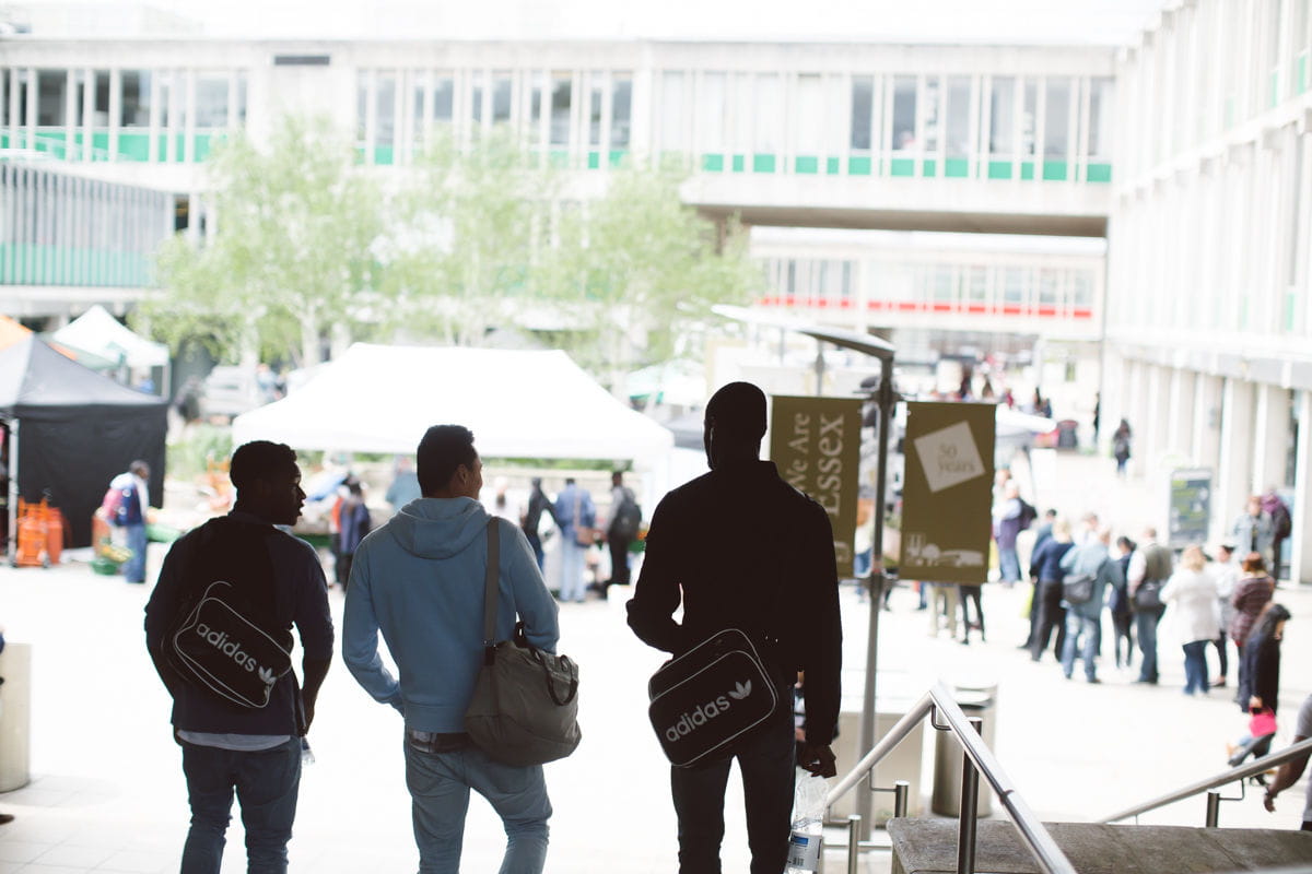 Three students walking down the steps on the University squares