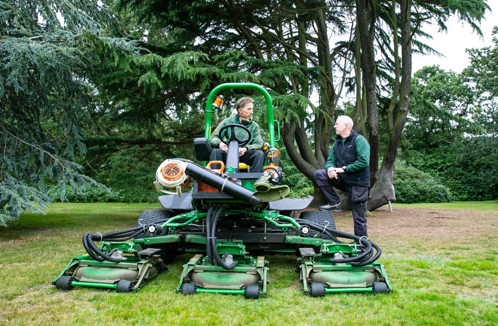 University grounds staff mowing the grass of Wivenhoe Park