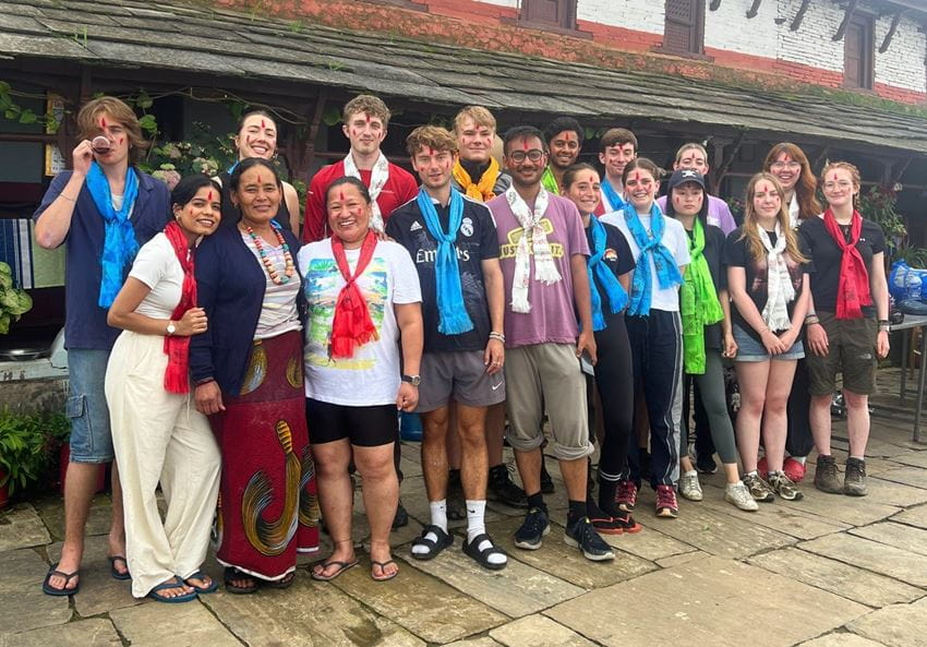 A group of people stand smiling for a photo in Nepal