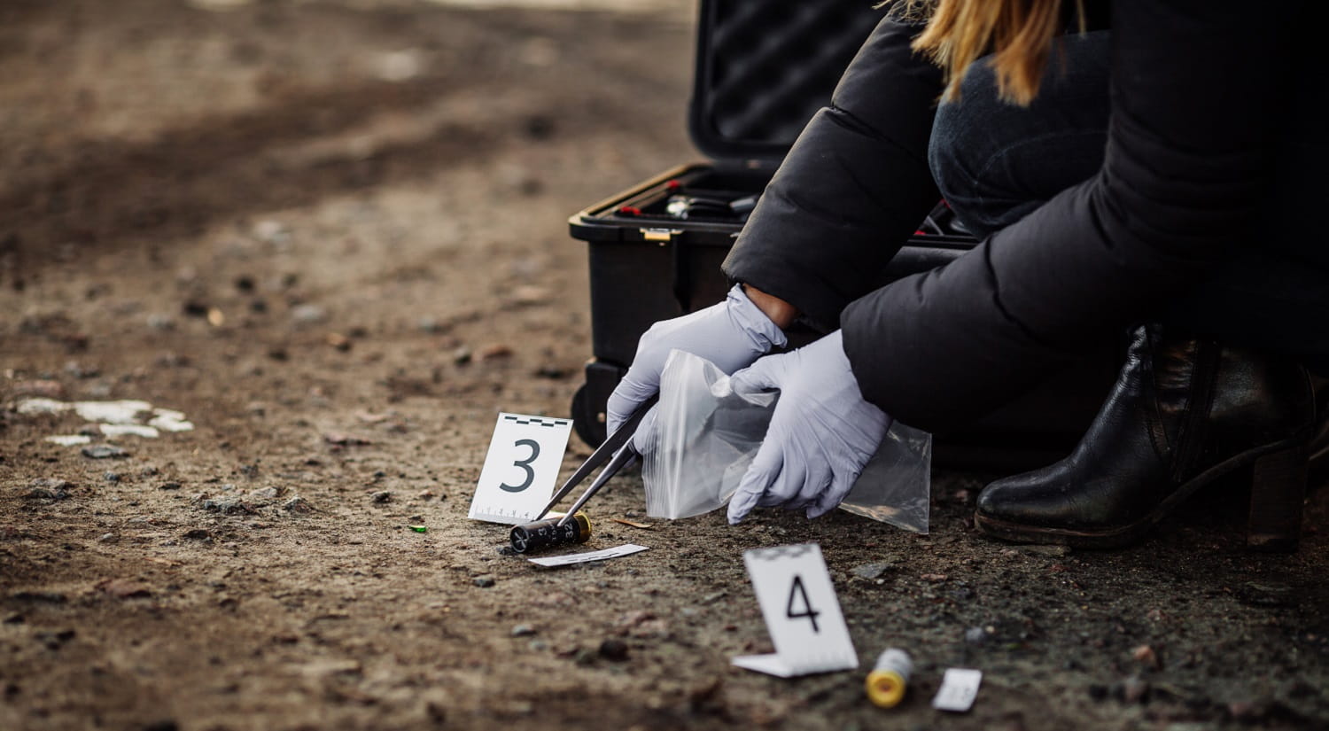 A woman collecting evidence from a crime scene