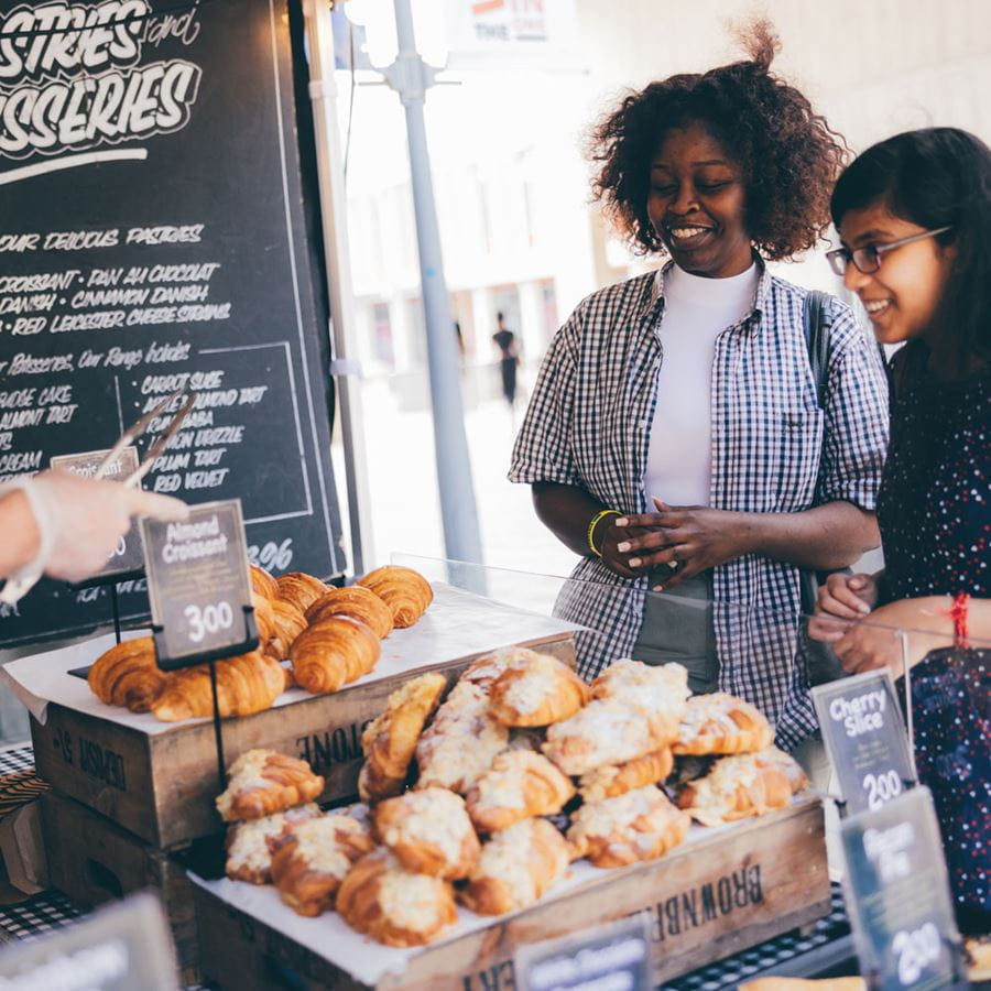 Students buying pastries at the Thursday Market on Colchester Campus Squares