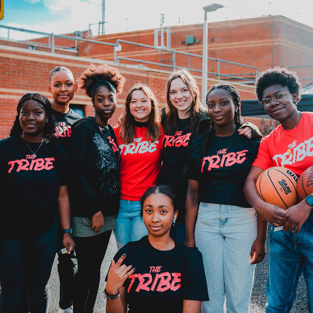 Group of female students outside the Essex Sport Arena wearing black and red Tribe tshirts
