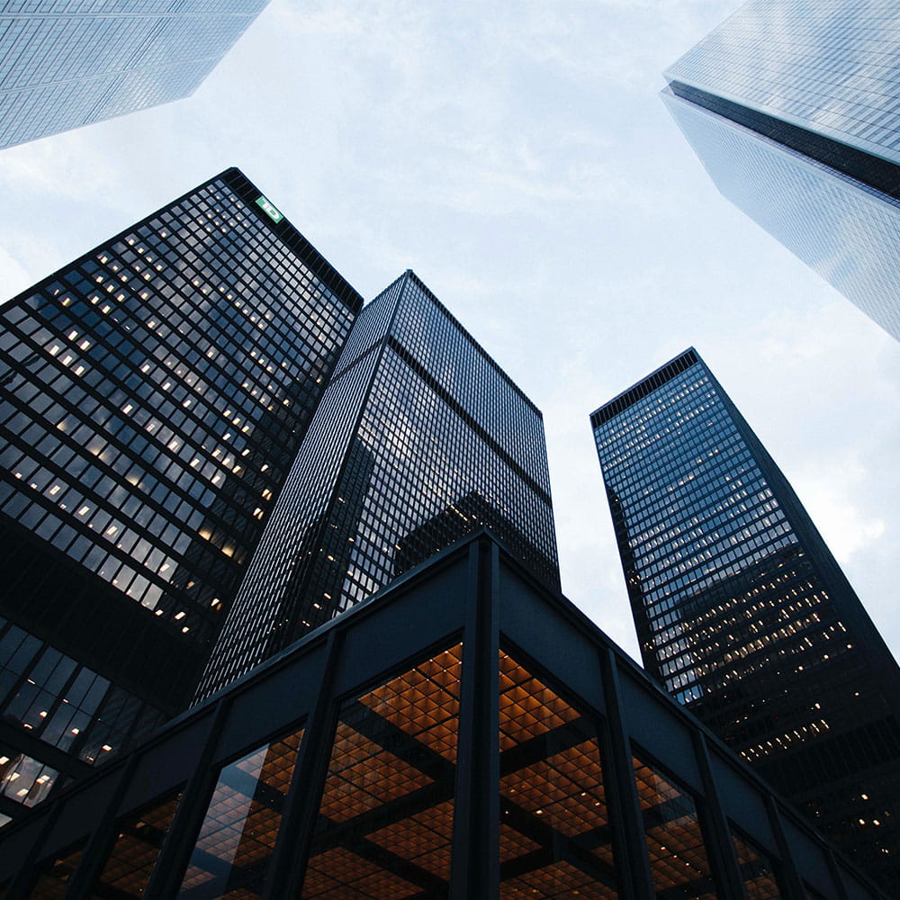 Low angle photo of city high rise buildings during daytime. Photo by Sean Pollock on Unsplash.