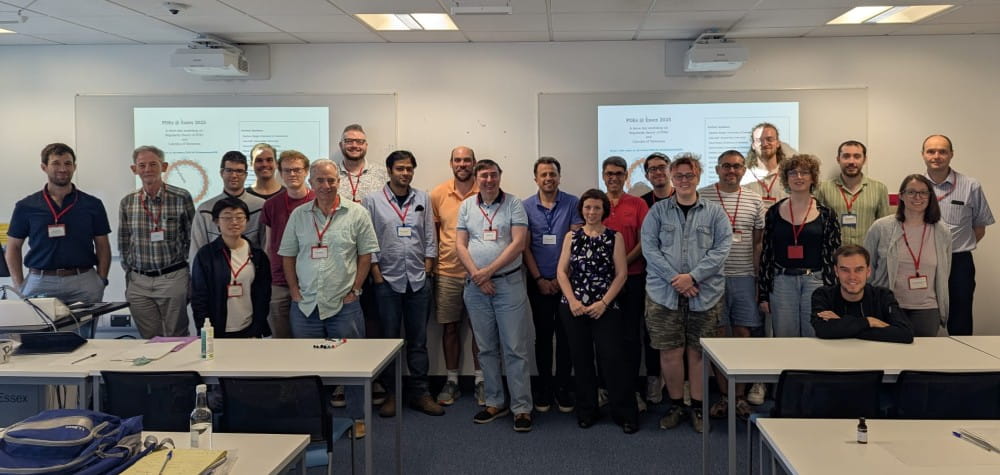 Photo of the participants of the PDE workshop, in a line in front of projector screens.