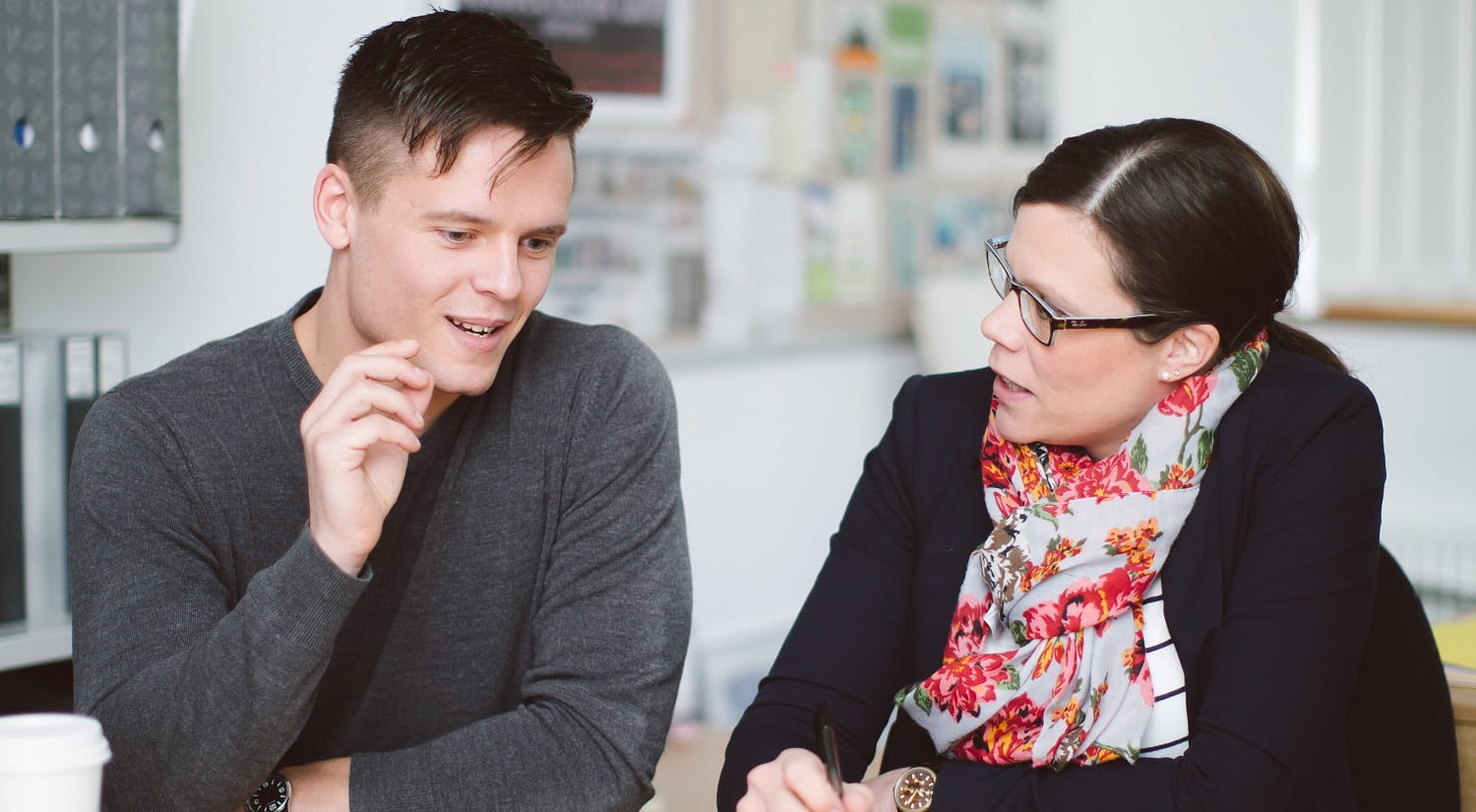 Professor Silke Paulmann sitting at a desk with a student, who is gesturing as he talks.