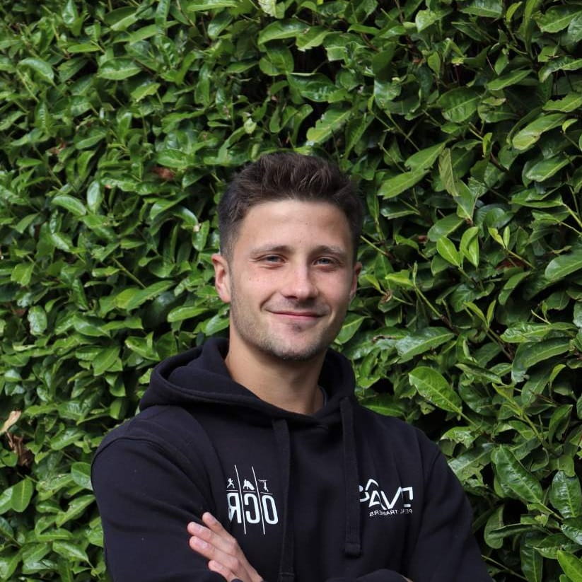 Ben Mendrys stood in front of hedge with arms folded.