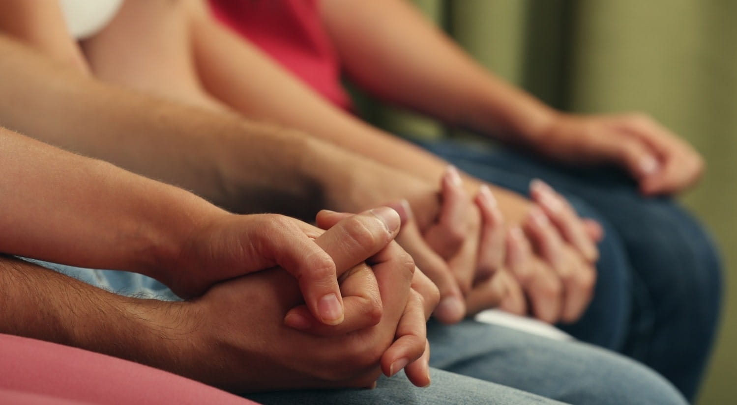 A group of people holding hands, representing therapeutic communication in a therapeutic organisation.