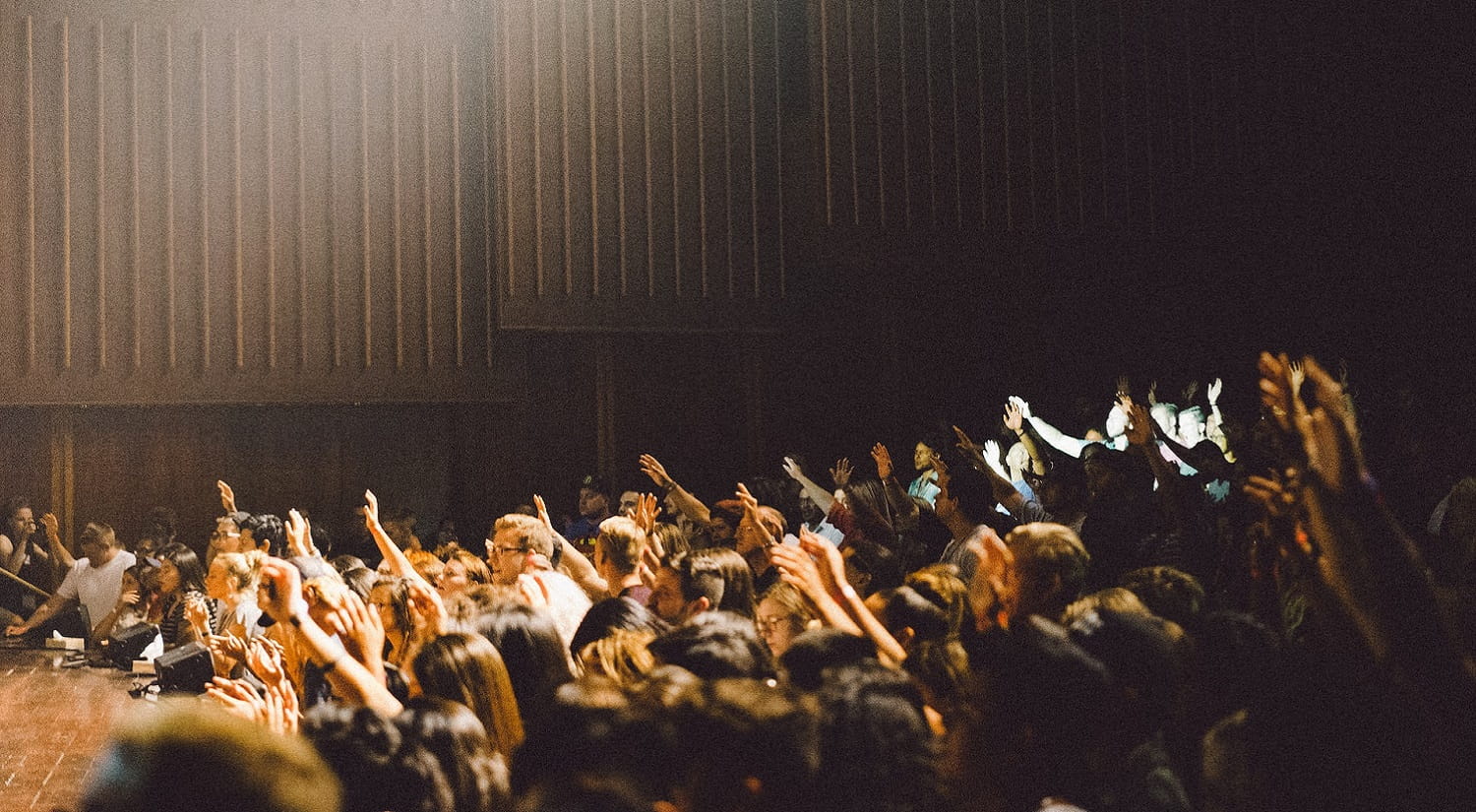 A  crowd of people pointing at a stage.