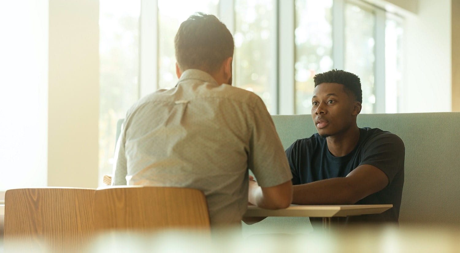 A young person talks with a mental health support worker, illustrating a career after taking the BA Psychodynamic Practice degree at Essex Uni.