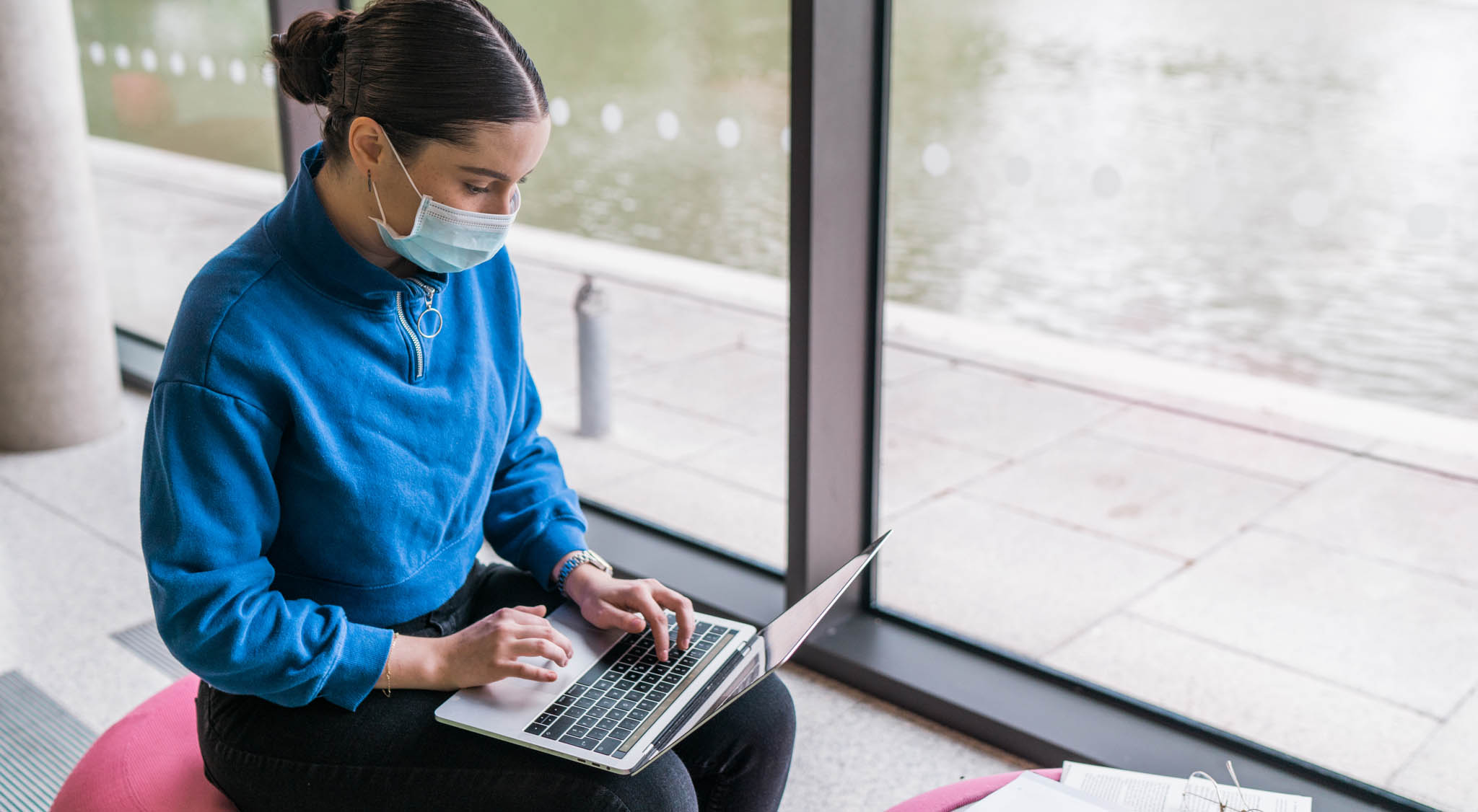 Student wearing a facemask using a laptop