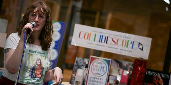 Alice K Stephens performing in front of a microphone at an Open Mic Night event.