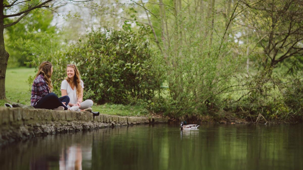 Students sitting by the lake chatting