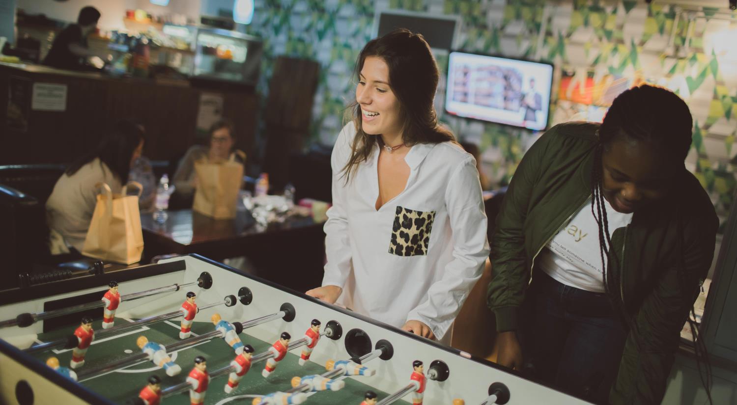 Students playing table football in the Students' Union lounge