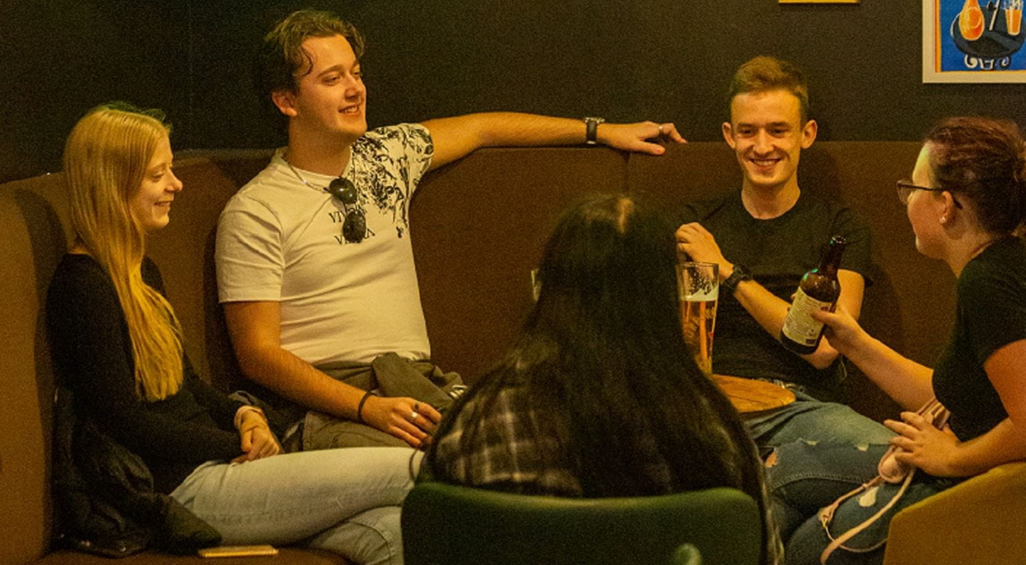 Students relax in the Colchester campus SU bar)