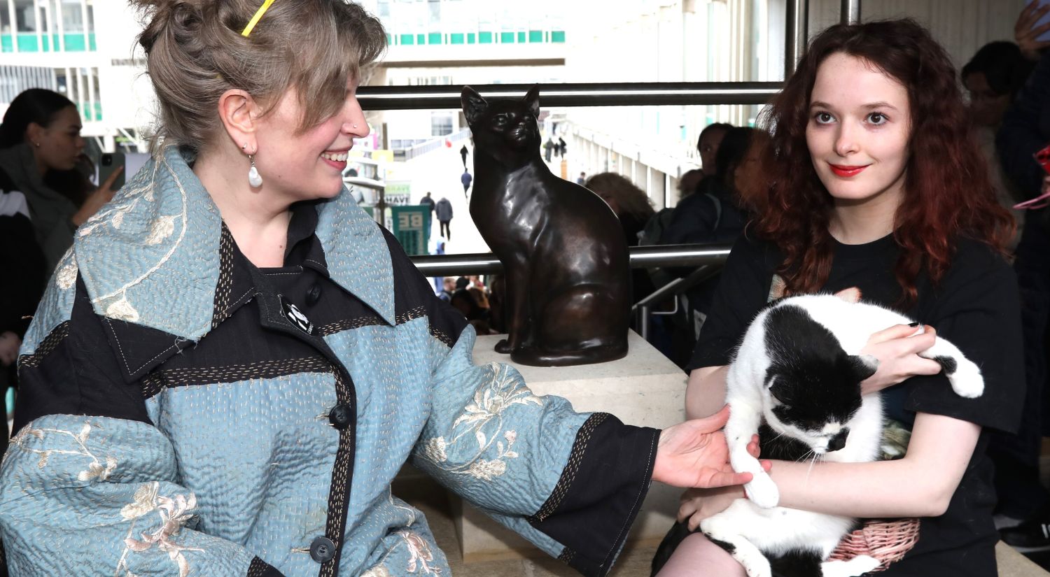 Chancellor Sarah Perry and student Gracie Mullane with Campus Cat and the new statue