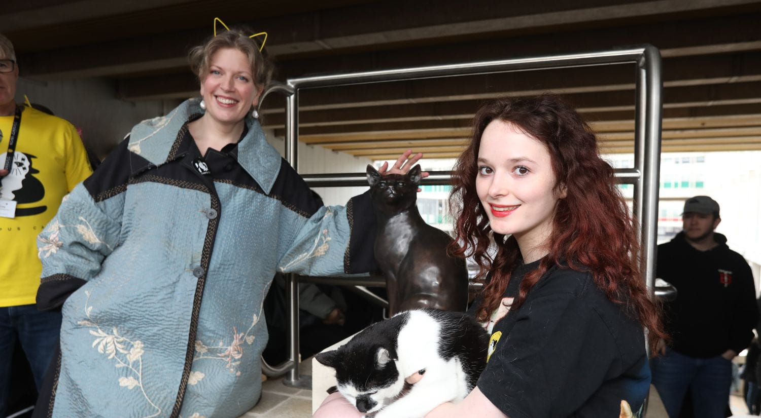 Chancellor Sarah Perry and student Gracie Mullane with Campus Cat and the new statue