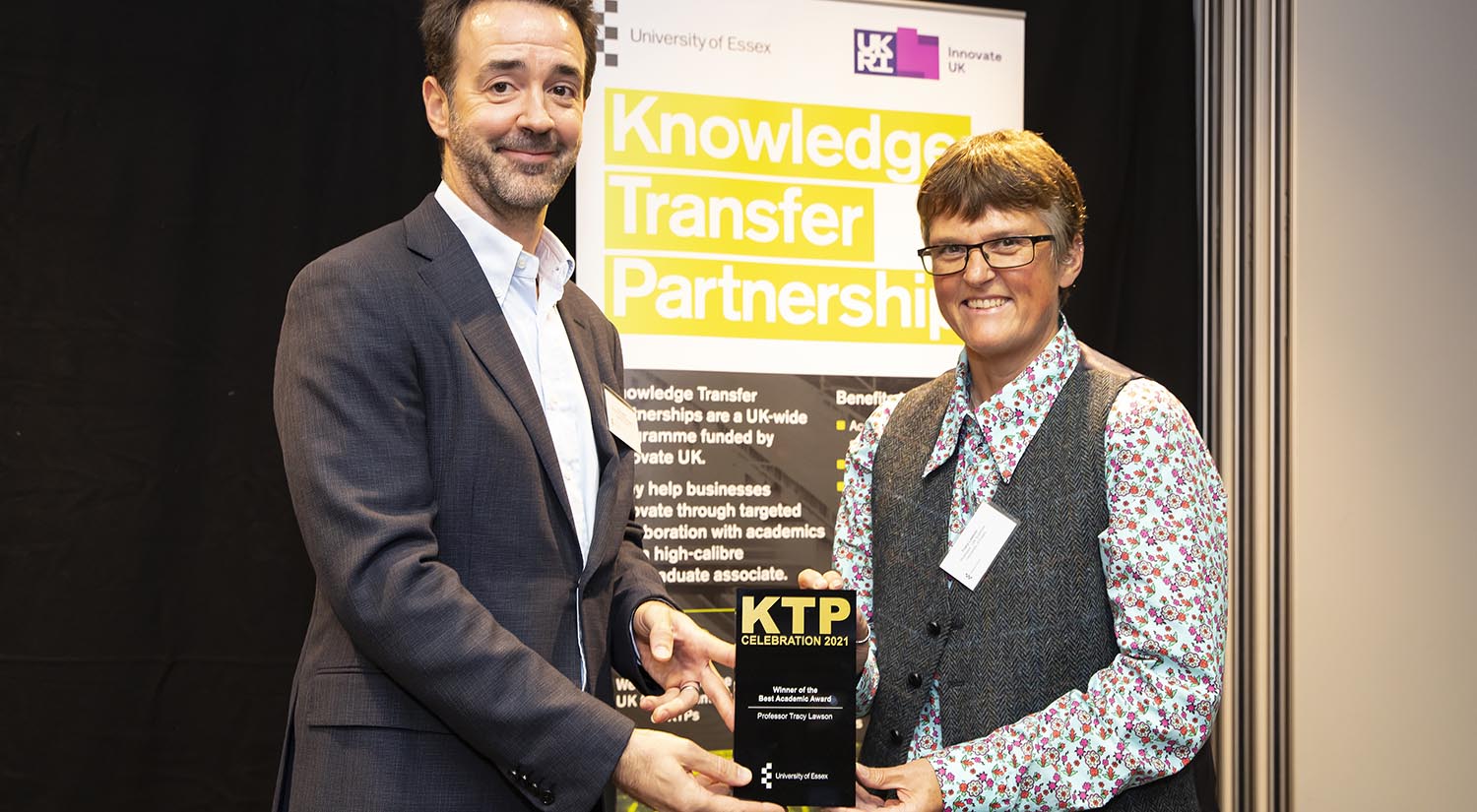 Professor Chris Greer handing the award to Professor Tracy Lawson