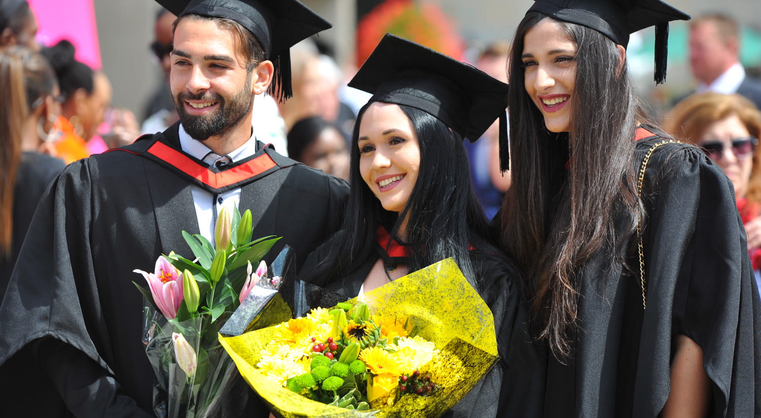 Three students in graduation robes