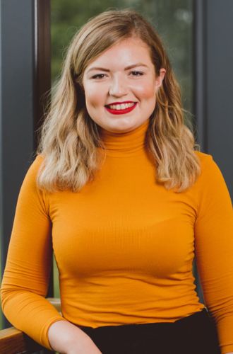 Dr Sarah Smyth, wearing a bright top smiling