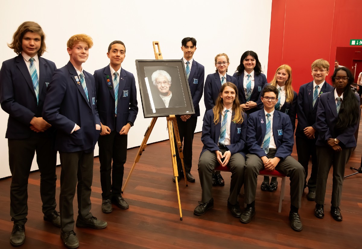 The St Helena School team next to a portrait of Dora Love