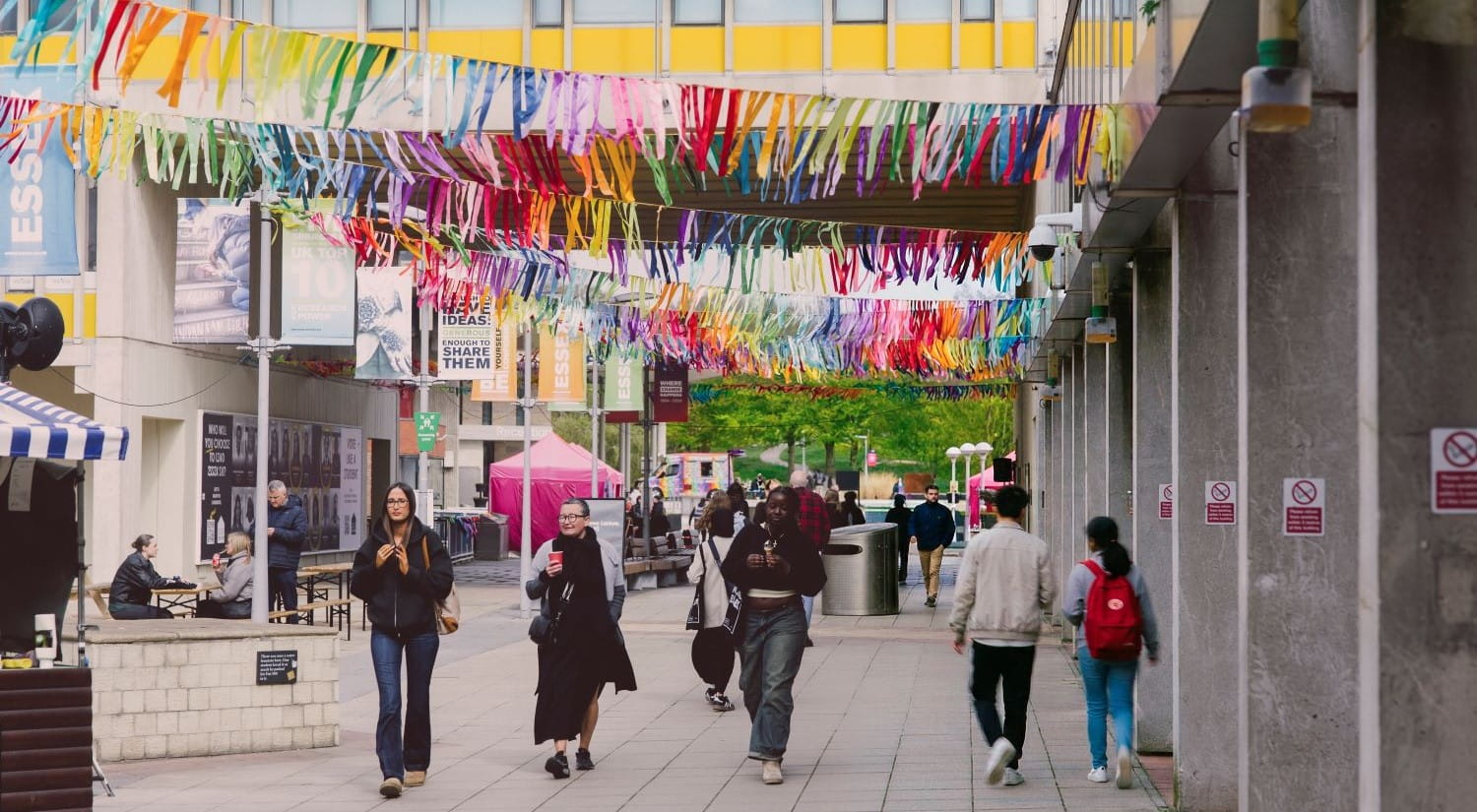 Group of people walking through colourfully decorated square