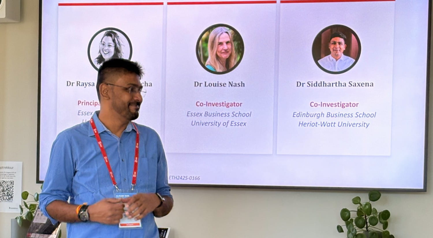 Dr Siddhartha Saxena standing in front of a screen showing a slide about three project co-investigators.