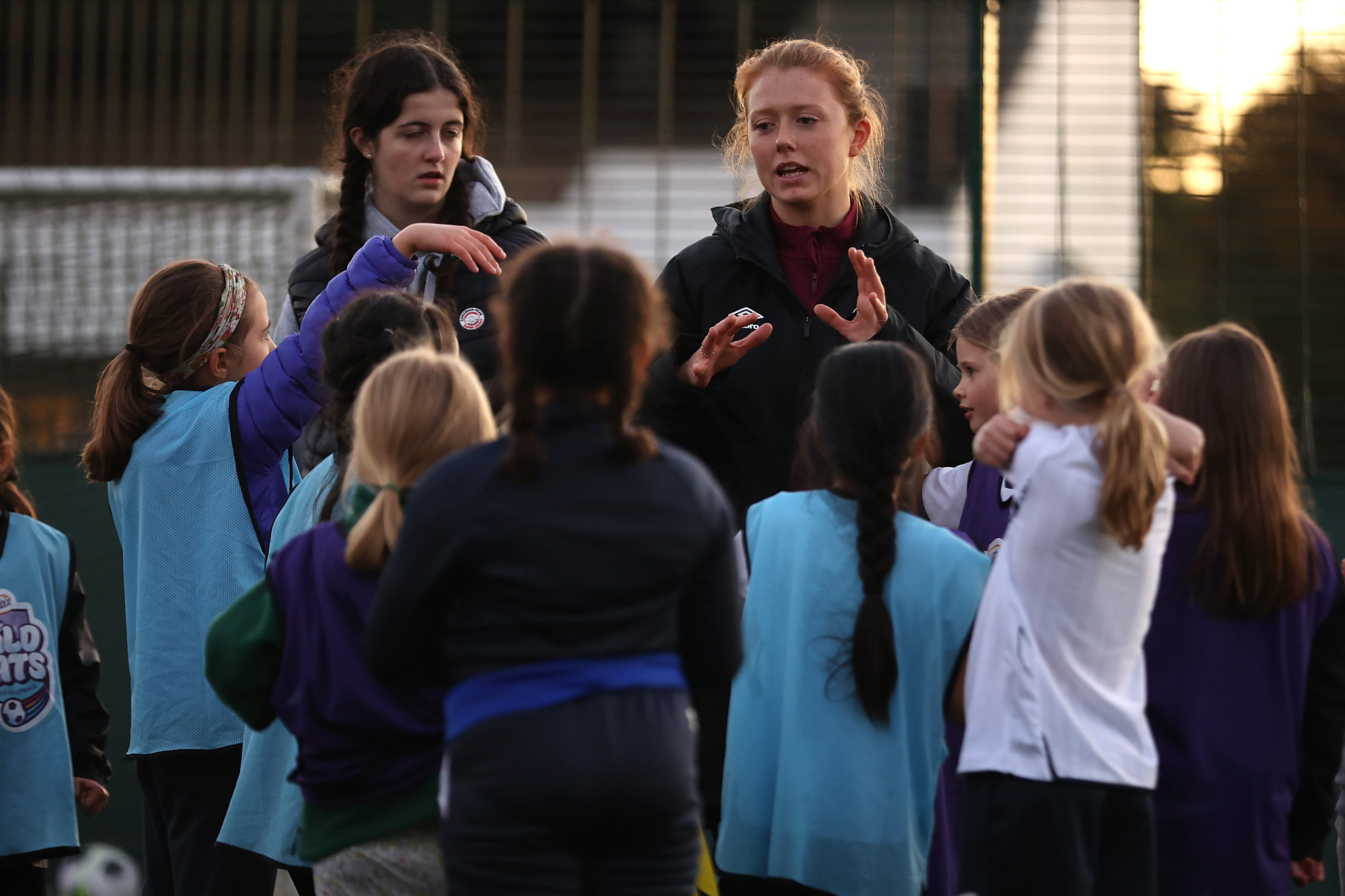 Group of football students being coached by Female coach