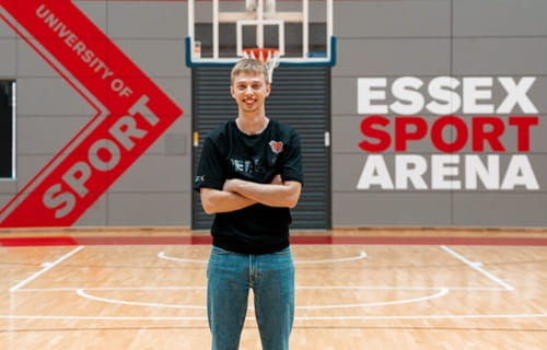 New women's basketball head coach Tor Freeman standing on court at Essex Sport Arena