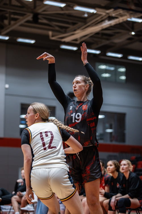 University of Essex and Essex Rebels women's basketball player Maria Blazejewski shooting a hoop against an opponent on court at Essex Sport Arena to support the team winning the BUCS South Premier Championship 