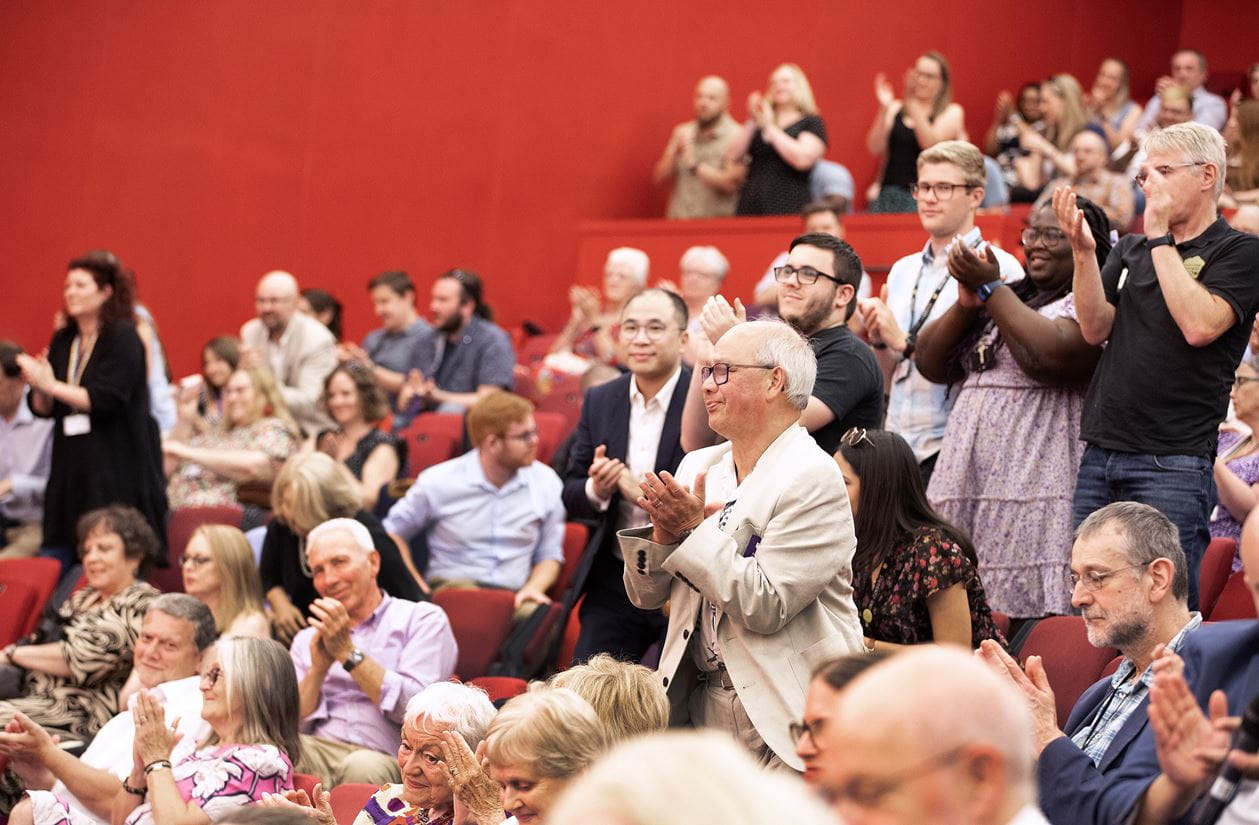 Members of Court and University stakeholders applaud the end of the Annual Meeting