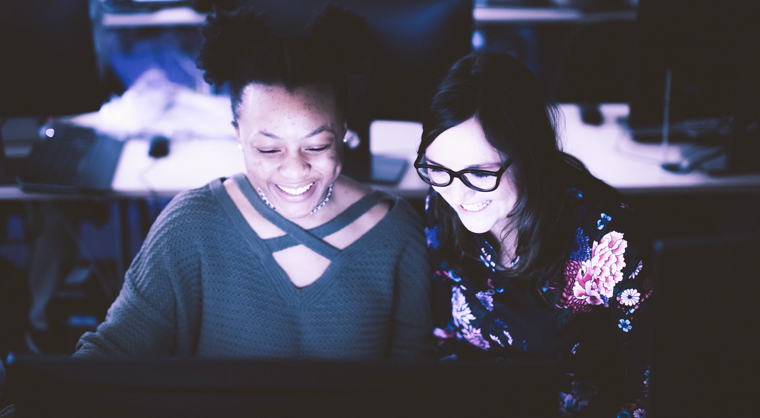 Image of a student and a member of staff working together in a PC lab