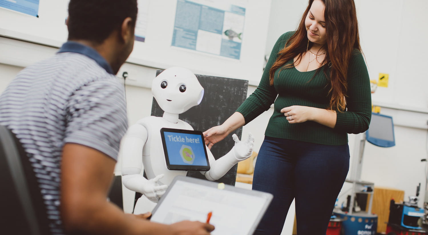Image of two students testing their interaction with a Pepper robot in our robot arena