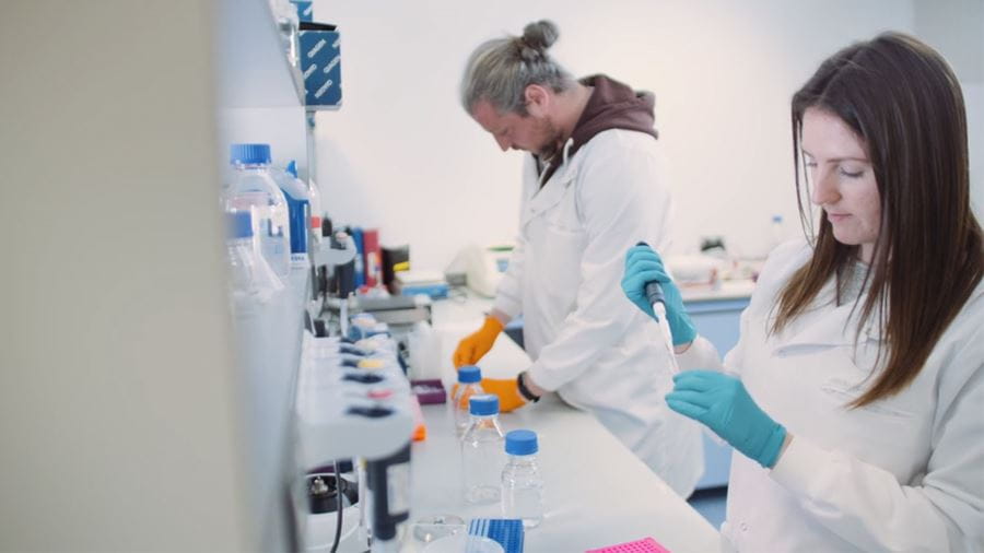 Images of two genetics students working in a lab