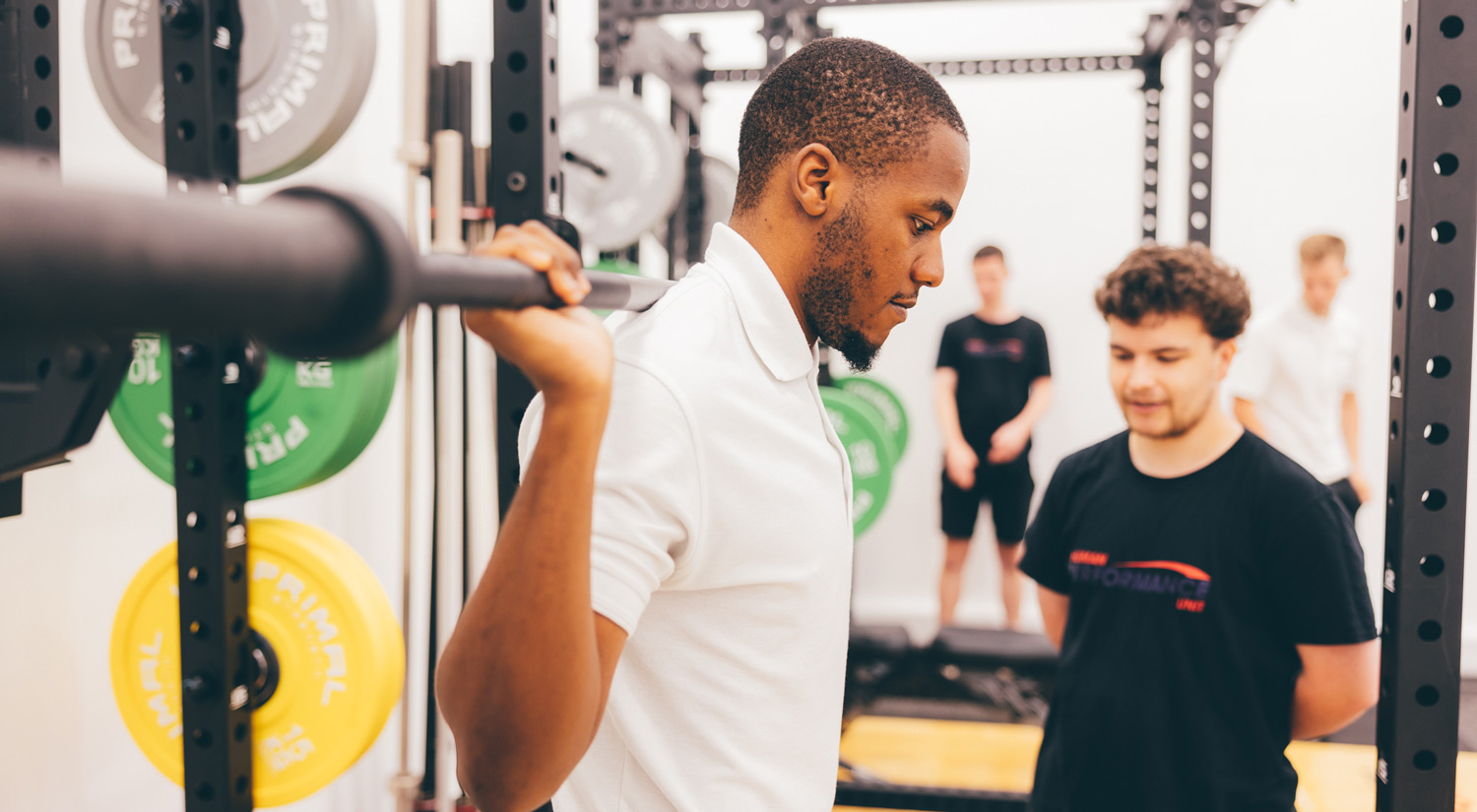 Sports science and Human Performance Unit students working together using strength and conditioning equipment