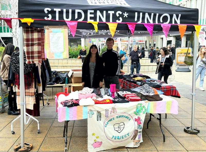 Two students managing the Clothes Exchange stall, Colchester campus
