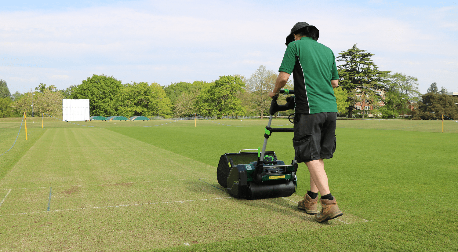 A person using a lawn mower to cut grass