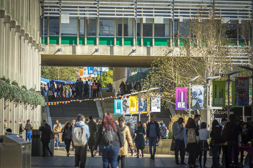 Students and staff wander across a sunny, colourful Square 3.