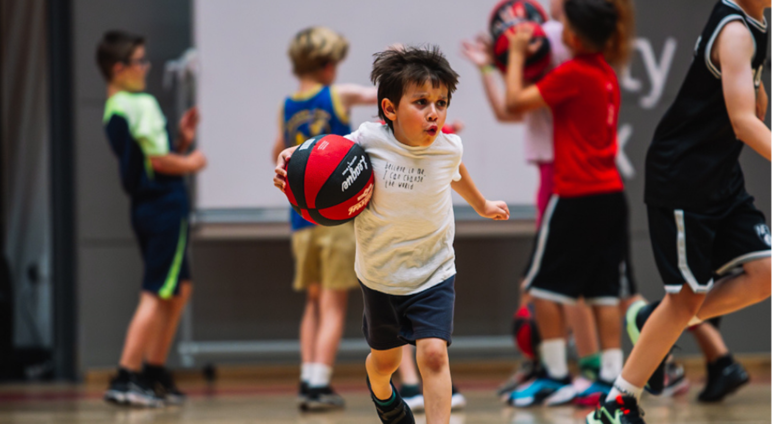Junior playing basketball indoors