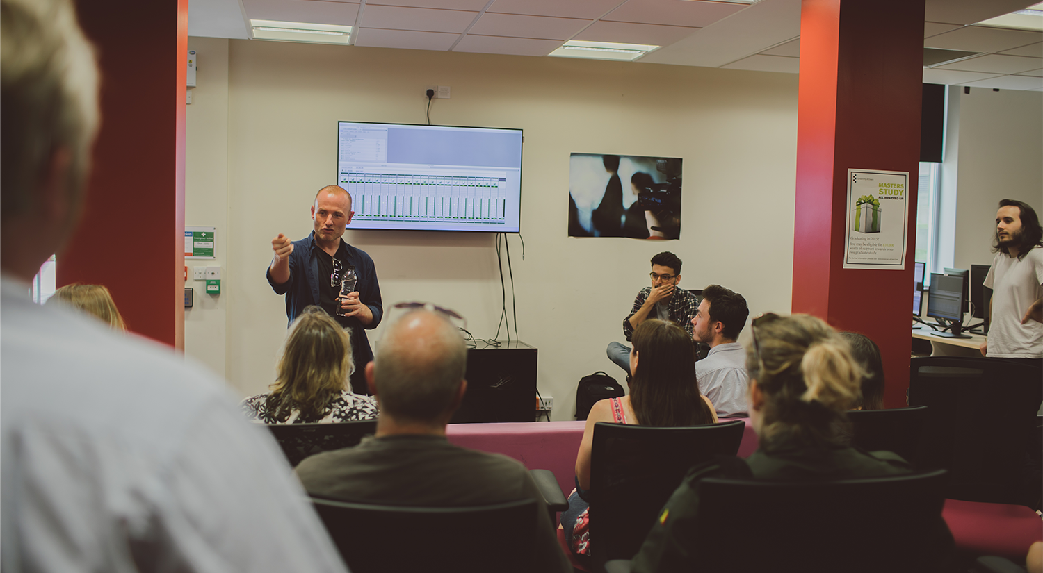 Faculty member talking to a group of people in a computer lab