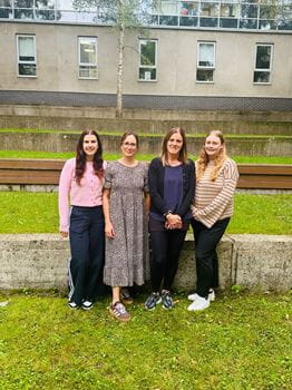 4 people sitting and smiling at the camera