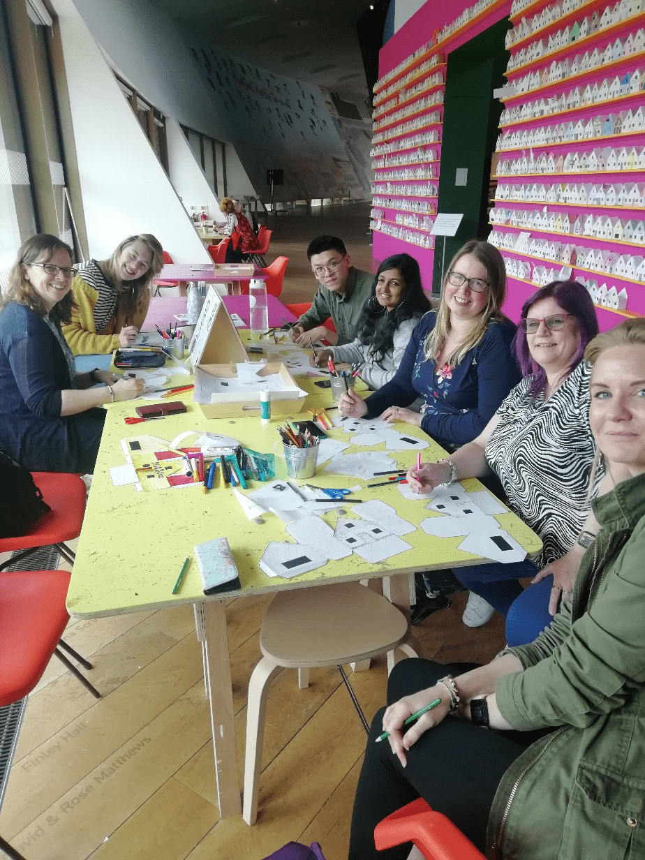 photo of people making paper models of houses