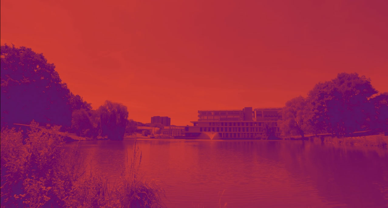 View of the Silberrad Student Centre from across the lake. Image has been heavily saturated with red and purple for artistic effect.