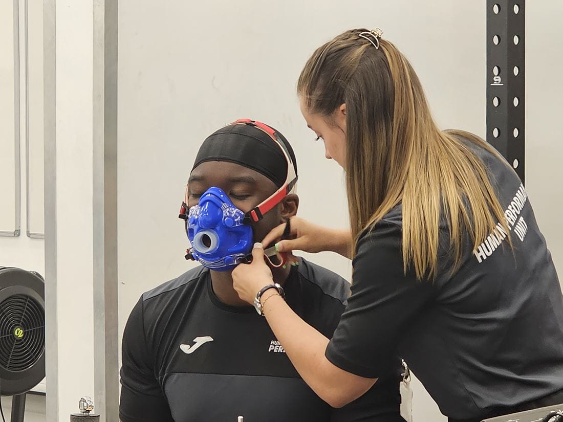 Student at the Human Performance Unit with an aerobic mask preparing for drumming