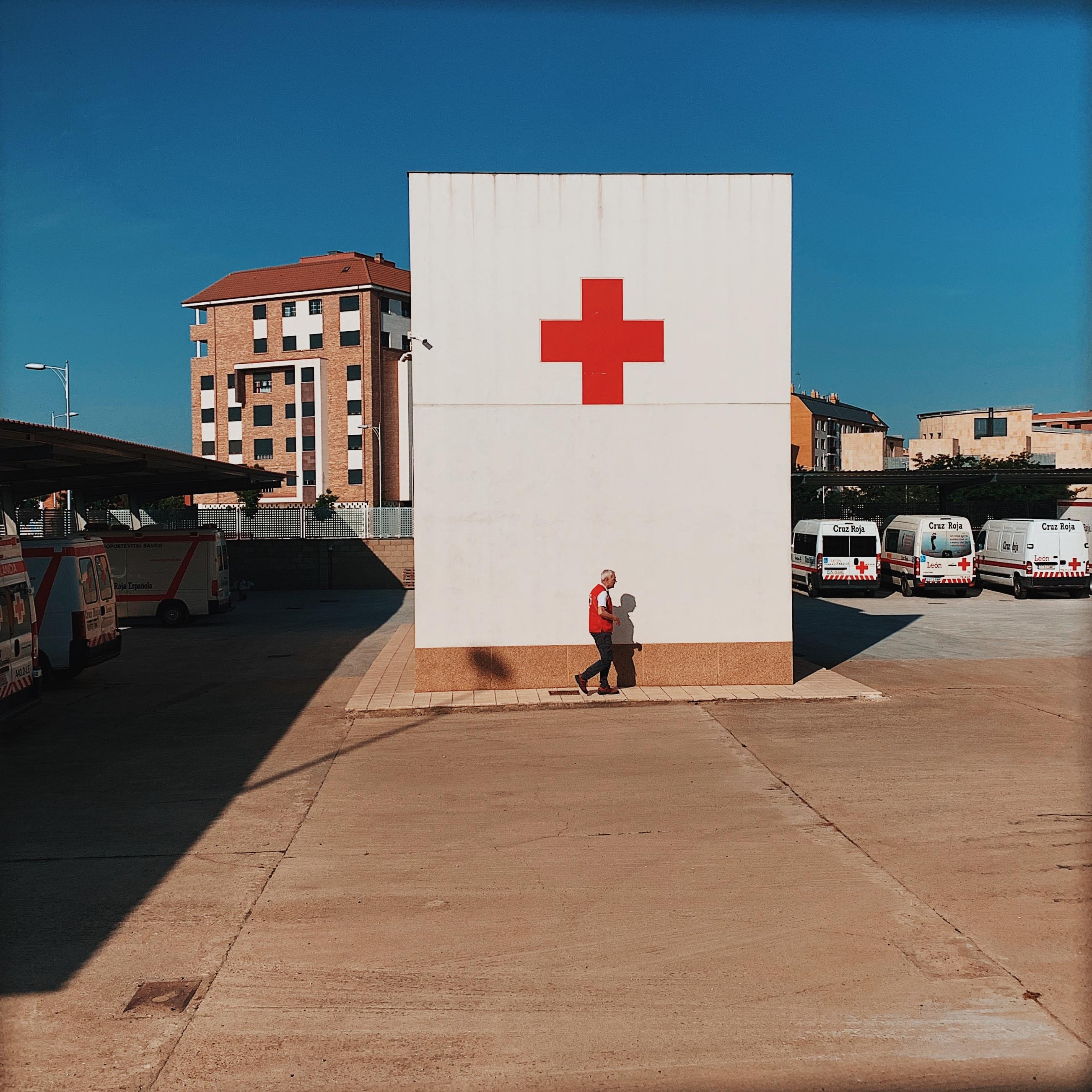 Someone standing in front of a building with a red cross
