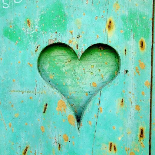A green wooden board with a heart cut out of it, another green board behind it.